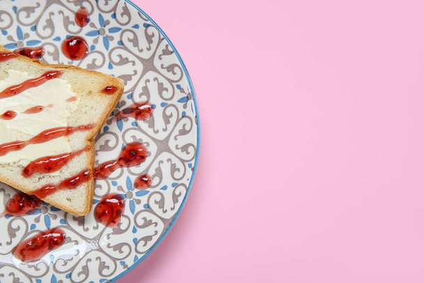 Plate of toast with butter and jam on pink background, closeup - Photo, Image