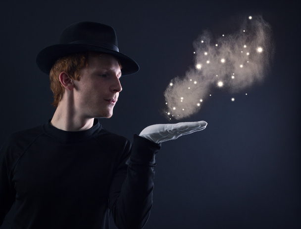 Magicien soufflant la poussière magique
 - Photo, image