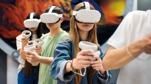 Tieners met VR-apparatuur. Een groep jongeren speelt met VR in de arena - Foto, afbeelding