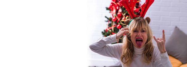 woman with a rebel gesture at christmas. hate christmas - Photo, Image