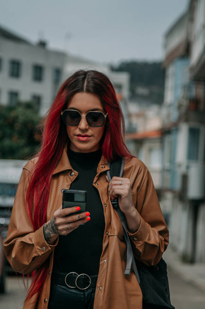 red hair tourist woman around the city with phone and backpack - Foto, immagini