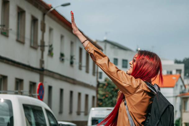 young girl with phone hailing a taxi on the street - Photo, Image