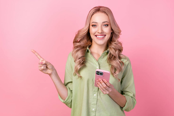 Photo of shiny cute lady wear green shirt typing modern gadget pointing empty space isolated pink color background. - Φωτογραφία, εικόνα