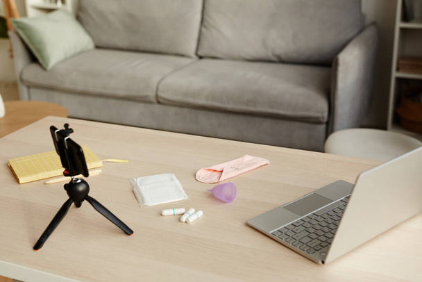 Фон изображения различных средств женской гигиены на столе со смартфоном камеры набора для просмотра видео, копирования пространства - Фото, изображение
