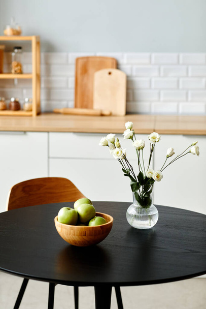 Clean background image of fresh flowers in vase on black kitchen table, copy space - Photo, Image