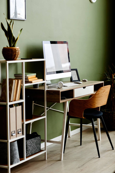 Immagine di sfondo a tutta lunghezza di home office sul posto di lavoro con computer su tavolo di legno contro parete verde - Foto, immagini