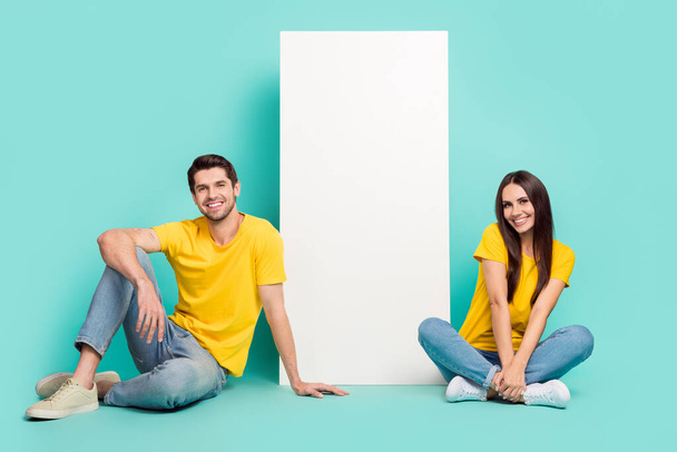 Photo of cute funny husband wife dressed yellow t-shirts reading modern device empty space isolated turquoise color background. - Fotografie, Obrázek