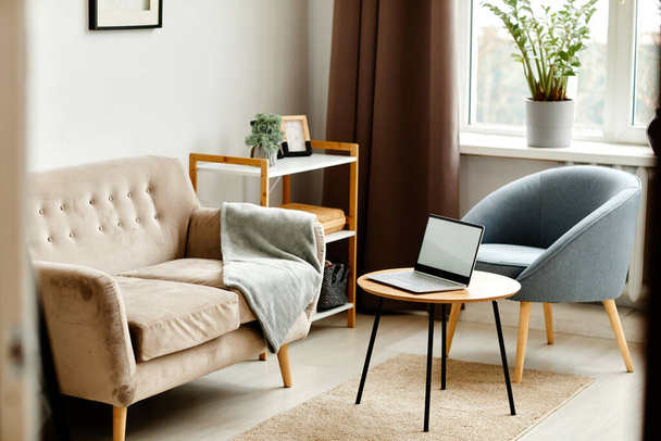 Background image of open laptop with blank white screen on coffee table in cozy minimalistic interior, copy space - Photo, Image