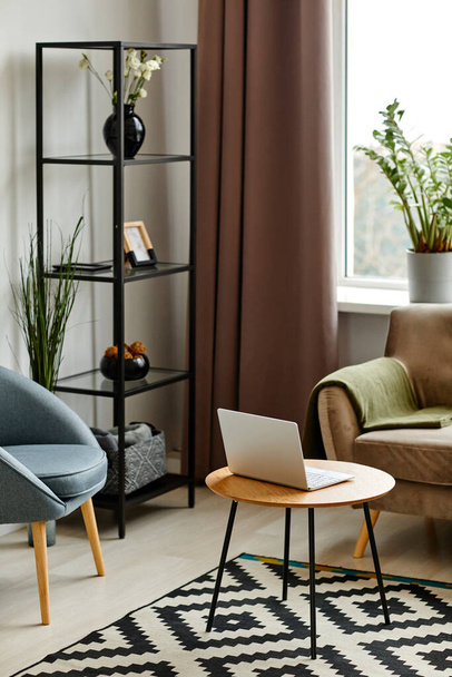 Függőleges kép a modern nappali belső tér nyitott laptoppal bársony kanapéval - Fotó, kép