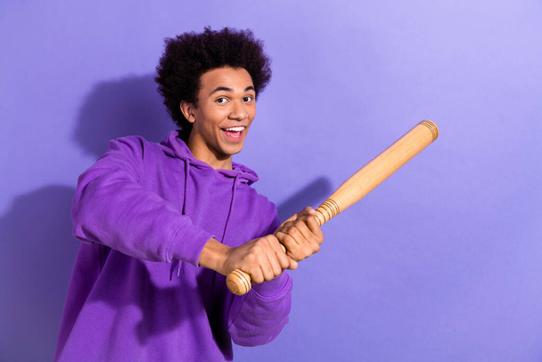 Photo of excited positive person have good mood hands hold baseball bat hit ball isolated on violet color background. - 写真・画像