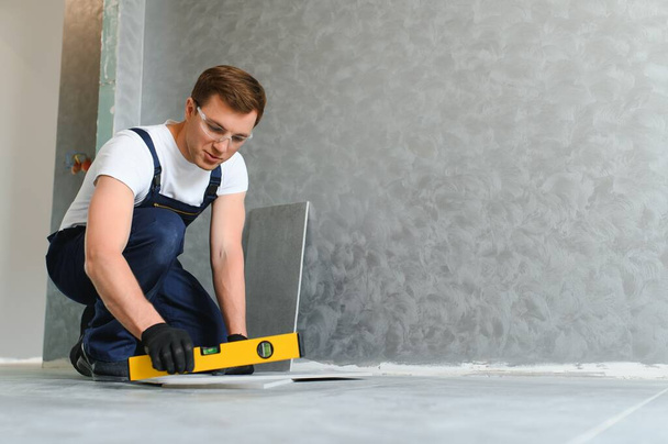 industrial worker, handyman installing ceramic tiles - Zdjęcie, obraz