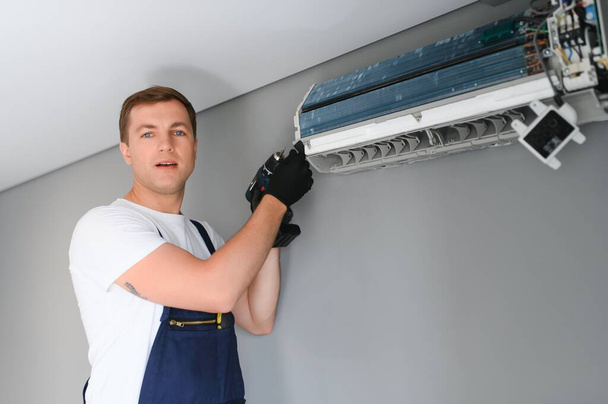 Technician repairing air conditioner on the wall. - Foto, Imagem