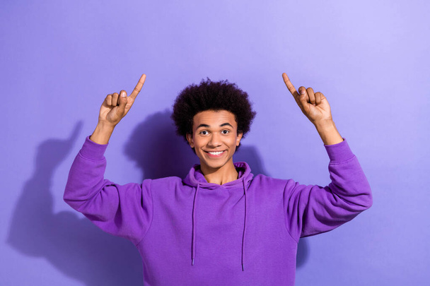 Portrait of positive person toothy smile direct fingers up above empty space offer isolated on purple color background. - Foto, imagen