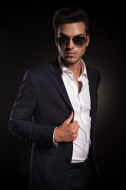 elegant business man posing on black studio background - Zdjęcie, obraz