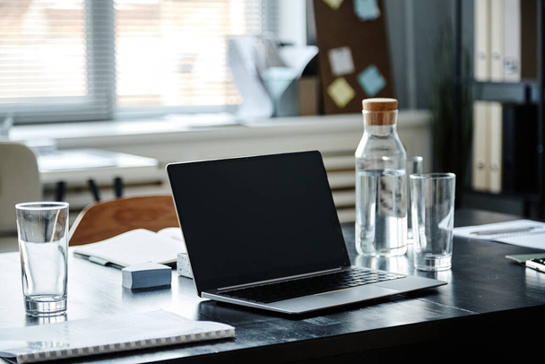 крупним планом відкритий ноутбук і пляшка води на столі для зустрічей в офісі, копіювати простір
 - Фото, зображення