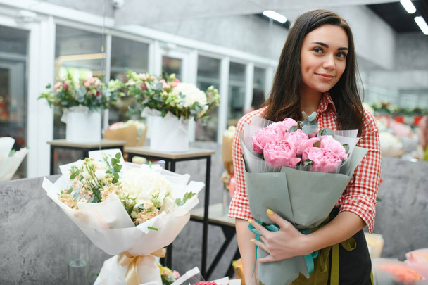 Beautiful young florist in flower shop. - Foto, Bild