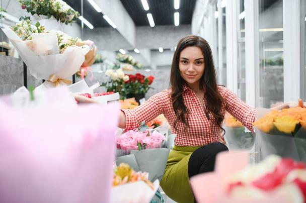 Beautiful young florist in flower shop. - Photo, Image