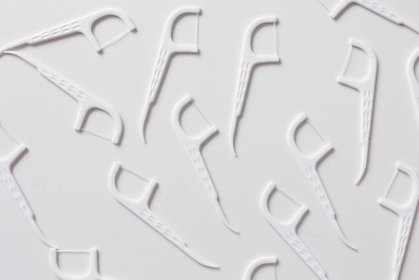 Composición plana con picos de hilo dental sobre fondo blanco - Foto, imagen