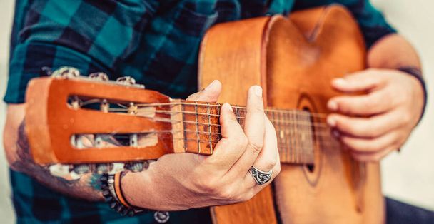 Male musician playing guitar, music instrument. Mans hands playing acoustic guitar, close up. Acoustic guitars playing. - Photo, Image