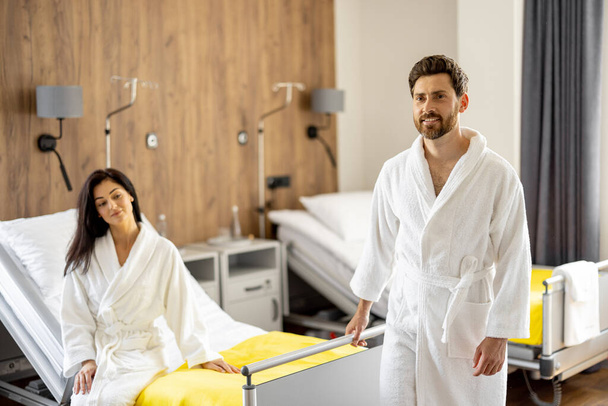 Man and woman resting in comfortable medical ward during rehabilitation after operation or medical procedures. High quality medical suites for resting - Zdjęcie, obraz