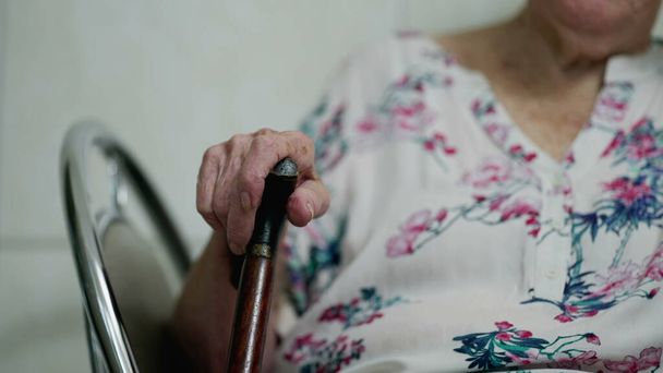 Una donna anziana caucasica premurosa che tiene in mano il bastone mentre riflette sui ricordi di life _ s, stile di vita di vecchiaia della persona anziana negli anni '80 - Foto, immagini