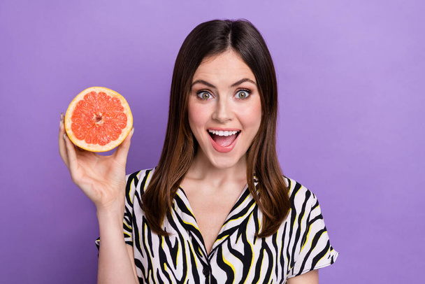 Photo of impressed cheerful lady hand hold half grapefruit toothy smile open mouth isolated on violet color background. - Zdjęcie, obraz