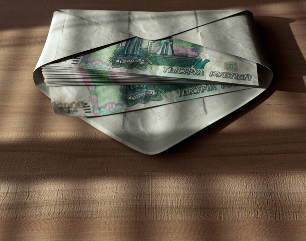 Een verspreidende stapel roebel bankbiljetten in een envelop op een houten ondergrond onder stemmige verlichting - 3D render - Foto, afbeelding