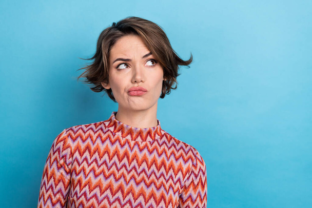 Photo of pretty serious lady looking side empty space suspicious person wear print shirt isolated blue color background. - 写真・画像