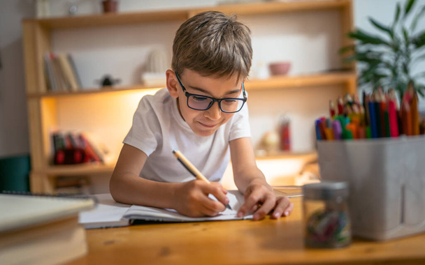 jong jongen kind kind leerling studie werk op huiswerk opdracht thuis - Foto, afbeelding