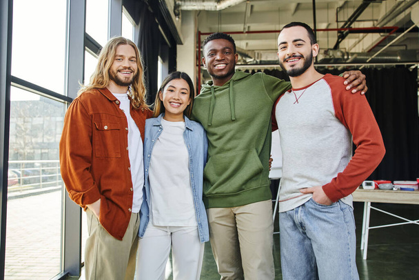 african american man embracing overjoyed interracial friends in stylish casual clothes looking at camera in modern office, diverse team business collaboration, startup project, entrepreneurship - Fotografie, Obrázek