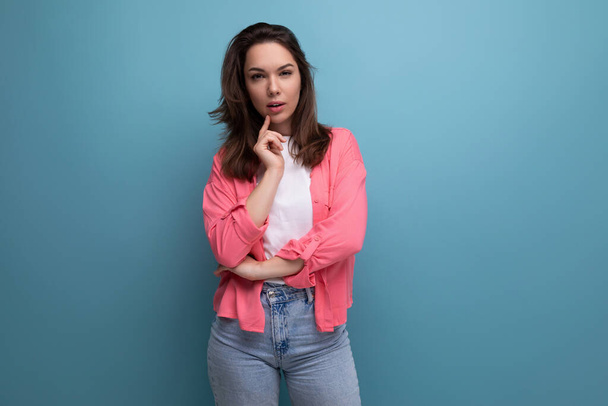calm brunette young woman with shoulder-length hair in a pink shirt and jeans. - Φωτογραφία, εικόνα