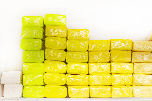 vários tons de massa de moldagem macia amarela embalados em um filme transparente. De volta à escola, Criatividade - Foto, Imagem