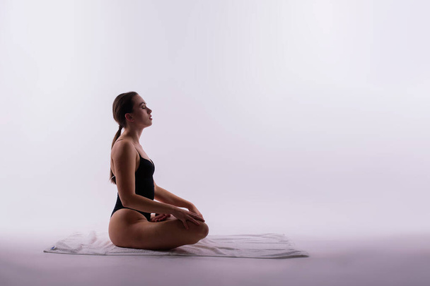 Красивая женщина позирует на занятиях по йоге. Снимок студии. - Фото, изображение
