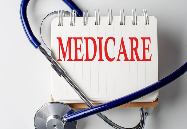 Palabra de Medicare en un cuaderno con equipo médico en segundo plano - Foto, imagen