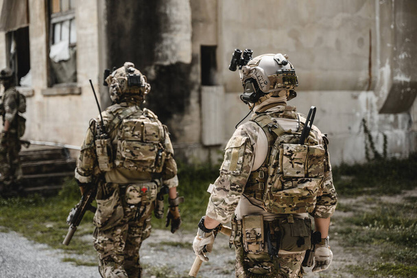 Экспертная группа солдат, атакующих противника во время военной операции, военнослужащие в защитной боевой форме, солдаты с винтовкой на поле боя - Фото, изображение