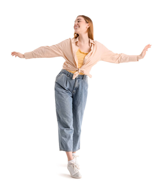 Young woman balancing on white background - Zdjęcie, obraz