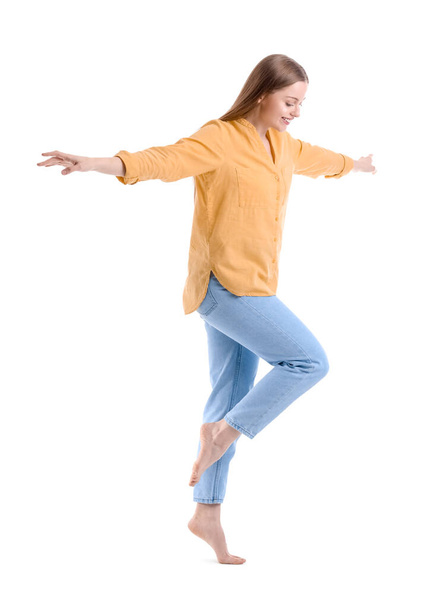 Mujer joven balanceándose sobre fondo blanco - Foto, Imagen