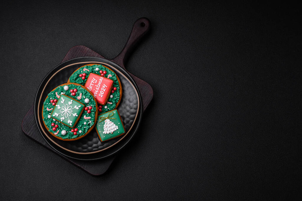 Köstliche frische süße Weihnachtslebkuchen mit festlichem Schmuck auf einem Keramikteller auf dunklem Betongrund - Foto, Bild