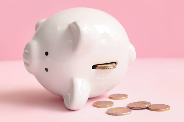 Piggy bank with money on pink background. Bankruptcy concept - Fotó, kép