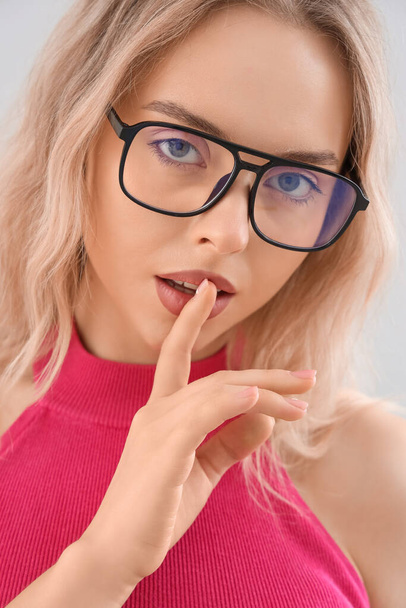 Young woman in stylish eyeglasses on light background, closeup - Foto, Imagem