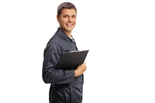 Auto mechanic holding a clipboard and smiling at camera isolated on white background - Photo, image