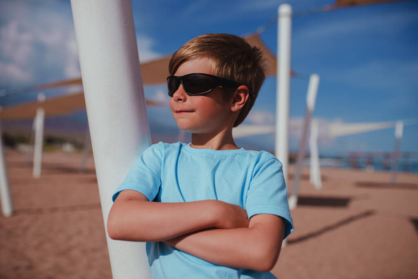 Portrait of handsome boy with sunglasses on the beach - Photo, Image