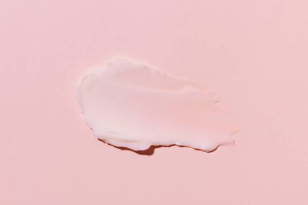 Close-up de amostra ou esfregaço de creme hidratante facial no fundo isolado rosa. Conceito de beleza e estética, cuidados com a pele e o rosto - Foto, Imagem