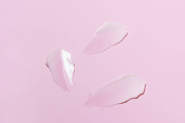 Swatch ή επίχρισμα της λευκής κρέμας προσώπου σε ροζ απομονωμένο φόντο. Έννοια προϊόντων ομορφιάς για περιποίηση δέρματος, αντηλιακή προστασία και ενυδάτωση - Φωτογραφία, εικόνα
