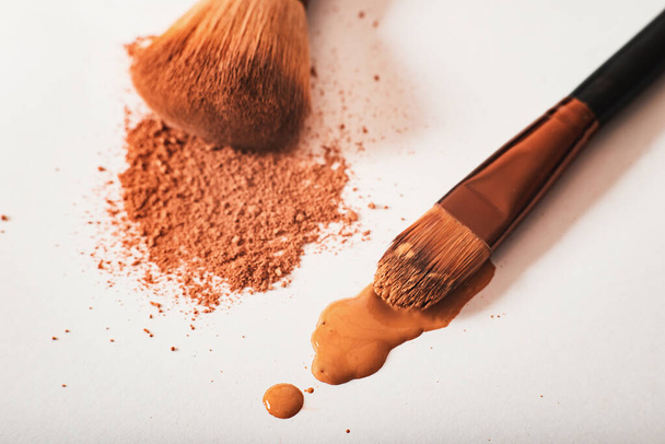 crumbly compact make-up powder in a nude tone with a large powder brush on a white background. Macro, close-up. Copy space, place for text, Cosmetics concept - 写真・画像