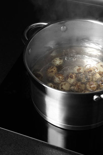 Cooking quail eggs in pot on electric stove - Fotografie, Obrázek