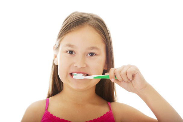 klein meisje poetsen tanden - Foto, afbeelding