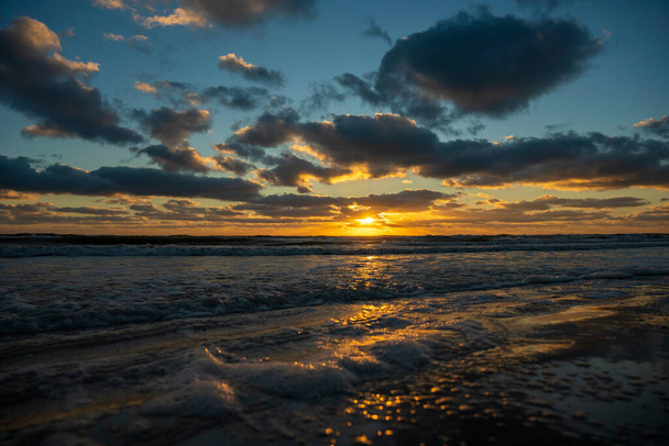 Ocean sunset landscape with soft evening sea water waves crushing on sandy beach. - Fotó, kép