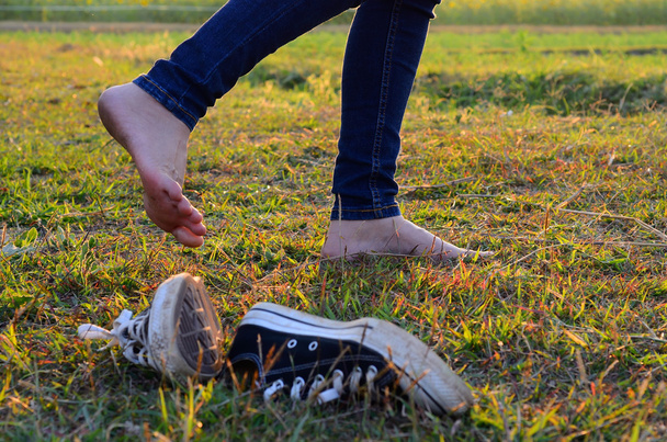 Kadın olanlar spor ayakkabı, bir çayır l ile yürürken çıkar - Fotoğraf, Görsel