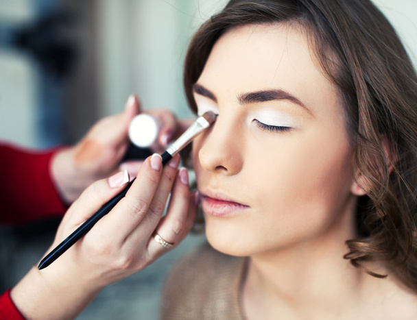 Woman applying makeup - Fotoğraf, Görsel